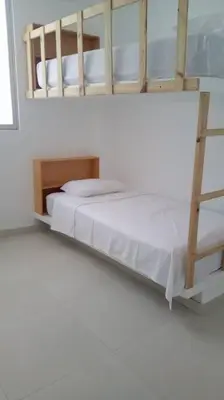 a white bedroom with a bunk bed and a ladder at Playa ChinchaHouse - Agradable casa de playa en Chinchaycamac in Chincha Baja