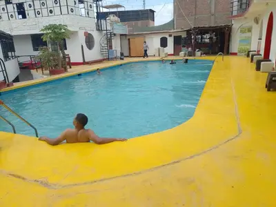 a young boy laying in a swimming pool at Hotel Duna Sur in Laguna Huacachina