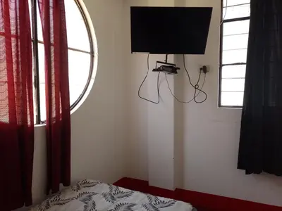 a bedroom with a bed and a tv on the wall at Hotel Duna Sur in Laguna Huacachina