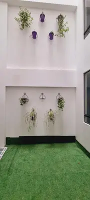 a white wall with potted plants on it at HOTEL LUZ GARDEN in Machu Picchu