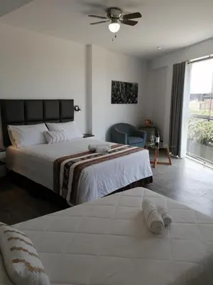 a bedroom with a large bed with a ceiling fan at Casa Yuraq Hotel Boutique in Chincha Alta