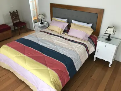a large bed with a colorful blanket and pillows at Loft grande cerca al Olivar en San isidro-Lima in Lima