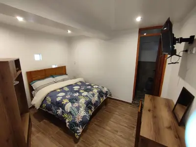 a bedroom with a bed and a television and a table at linda house cusco in Cusco