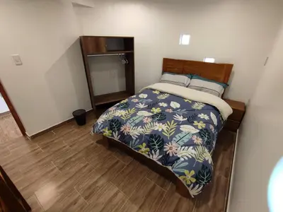 a bedroom with a bed with a floral bedspread at linda house cusco in Cusco
