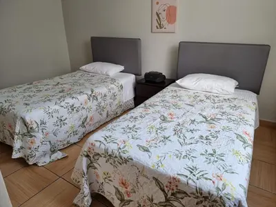 two beds sitting next to each other in a room at Apart Hotel Doña Esther in Lima