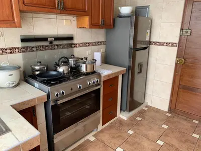 a kitchen with a stove and a refrigerator at Apart Hotel Doña Esther in Lima