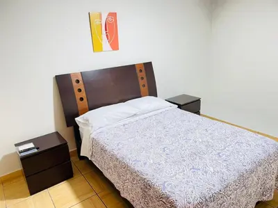 a bedroom with a large bed with two night stands at Apart Hotel Doña Esther in Lima