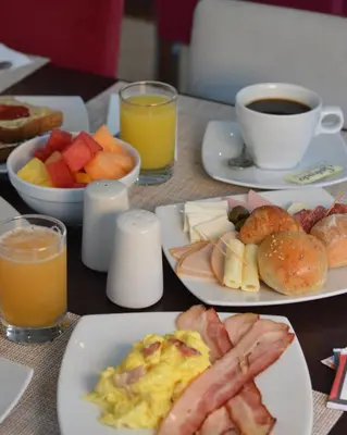 a table topped with plates of breakfast foods and drinks at Sol de Oro Hotel & Suites in Lima