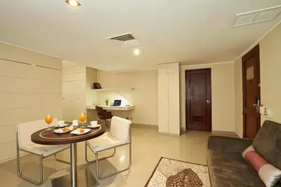a living room with a table and a couch at Sol de Oro Hotel & Suites in Lima