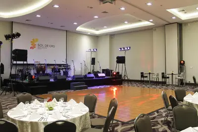 a banquet hall with tables and chairs and a stage at Sol de Oro Hotel & Suites in Lima