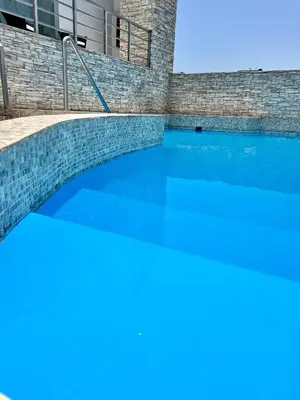a swimming pool with blue water in a building at Sol de Oro Hotel & Suites in Lima