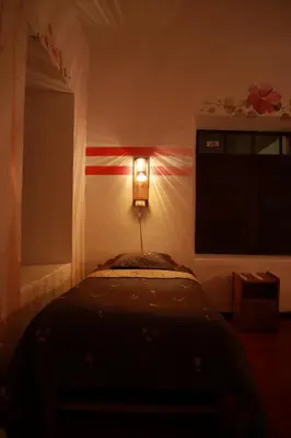 a bedroom with a bed and a light on the wall at Tiyana House in Cusco