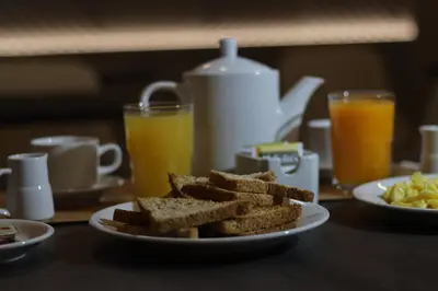 a plate of toast on a table with two glasses of orange juice at Hotel Rey in Huancayo