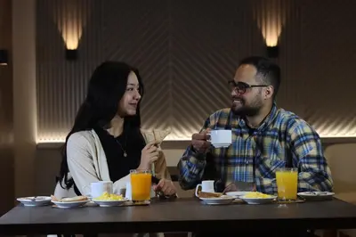 a man and a woman sitting at a table with food at Hotel Rey in Huancayo