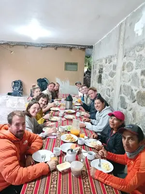 a group of people sitting at a long table eating food at Lia B&B Lucmabamba in Sahuayacu