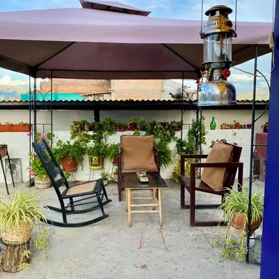 a group of chairs sitting under a purple umbrella at Departamento céntrico con terraza ideal para grupos in Ayacucho
