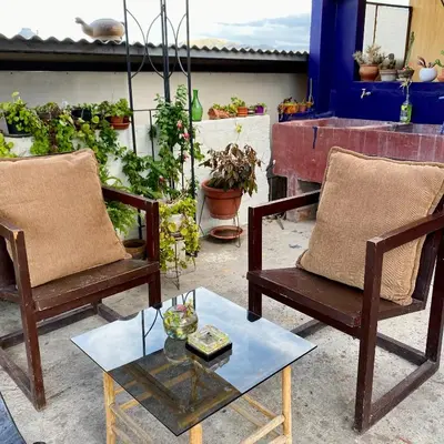 a patio with two chairs and a table and plants at Departamento céntrico con terraza ideal para grupos in Ayacucho