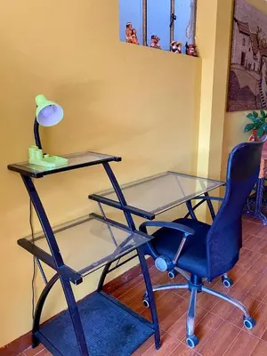 a glass desk and a chair and a lamp at Departamento céntrico con terraza ideal para grupos in Ayacucho