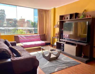 a living room with a large television and a couch at Departamento céntrico con terraza ideal para grupos in Ayacucho