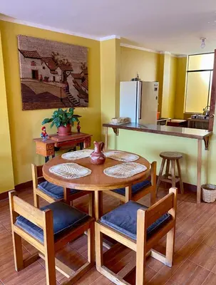 a kitchen with a table and some chairs and a counter at Departamento céntrico con terraza ideal para grupos in Ayacucho