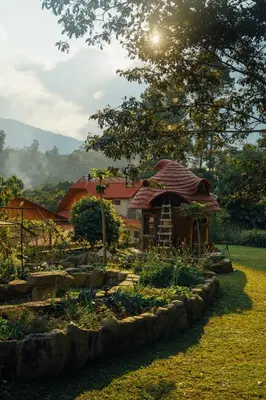 a garden with a small house in the background at Casa al lado del Bosque in Oxapampa