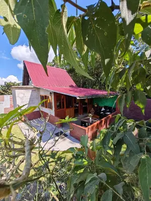 a small house with a red roof at Casa al lado del Bosque in Oxapampa