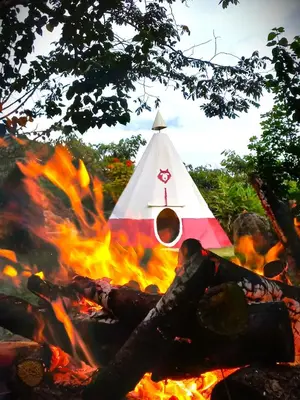 a fire with a pyramid in the background at Biosfera Lodge tipi para 3 personas in Oxapampa
