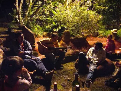 a group of people sitting around a fire pit at BIOSFERA LODGE GLAMPING tipi 2 personas in Oxapampa