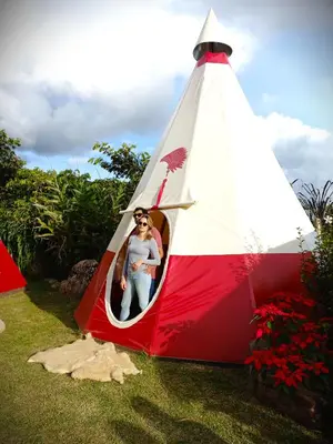 a woman is inside of a red and white tent at BIOSFERA LODGE GLAMPING tipi 2 personas in Oxapampa