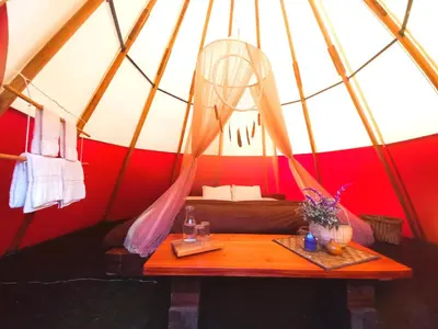 a room with a bed and a table in a yurt at BIOSFERA LODGE GLAMPING tipi 2 personas in Oxapampa