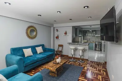 a living room with a blue couch and a table at San Pedro Apartments in Cusco