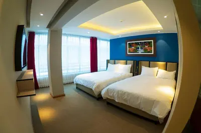 two beds in a room with blue walls and windows at R&N SHULLKAS SUITES in Huancayo