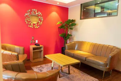 a waiting room with a couch and a table at R&N SHULLKAS SUITES in Huancayo