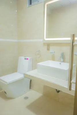 a bathroom with a sink and a toilet and a mirror at R&N SHULLKAS SUITES in Huancayo