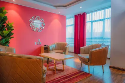 a waiting room with red walls and a table and chairs at R&N SHULLKAS SUITES in Huancayo