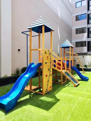 a playground with two slides and a slide at El Sol by Wynwood House in Lima