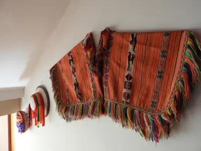 a blanket is hanging on a wall at Ayllu B&B Ollantaytambo in Ollantaytambo