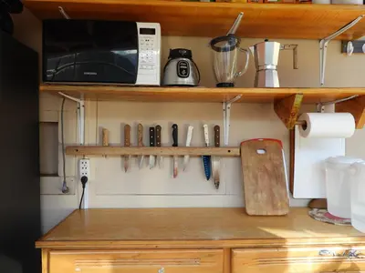 a kitchen counter with utensils hanging on a wall at Ayllu B&B Ollantaytambo in Ollantaytambo