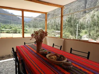 a table in a room with a view of a mountain at Ayllu B&B Ollantaytambo in Ollantaytambo
