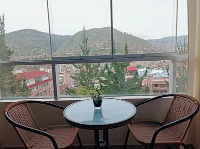 a table and two chairs in front of a window at Union Garden Apartments in Cusco
