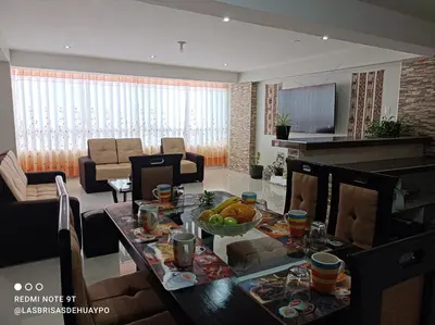 a living room with a table with a bowl of fruit on it at Union Garden Apartments in Cusco