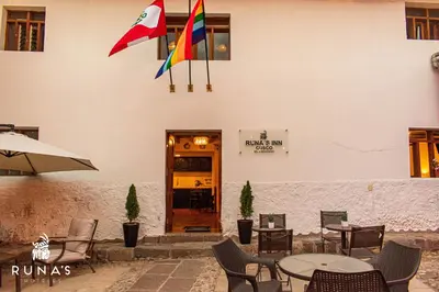 a restaurant with tables and chairs and a building at Rumi's Inn in Cusco