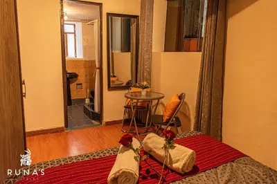 a room with a bed and a table in a room at Rumi's Inn in Cusco