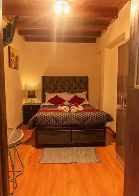 a bedroom with a large bed with red pillows at Rumi's Inn in Cusco