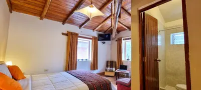a bedroom with a bed and a walk in shower at Casa de Ollanta ByB in Ollantaytambo