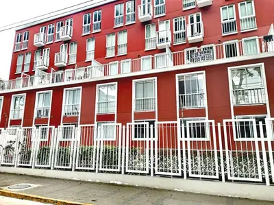 a red building with white windows and a fence at Espacio Luxury Apartments - Edificio Pedro de Osma in Lima