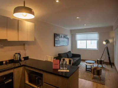 a kitchen and living room with a couch and a table at Espacio Luxury Apartments - Edificio Pedro de Osma in Lima