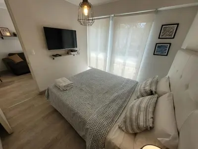 a bedroom with a bed and a flat screen tv at Espacio Luxury Apartments - Edificio Pedro de Osma in Lima