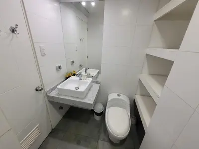 a white bathroom with a toilet and a sink at Espacio Luxury Apartments - Edificio Pedro de Osma in Lima
