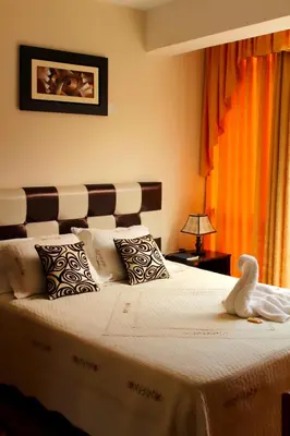 a bedroom with a large bed with white sheets and pillows at Hotel Conquistador in Andahuaylas